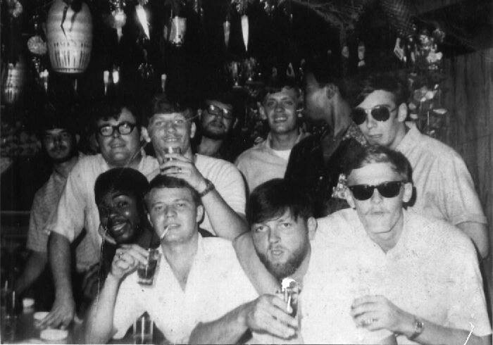 Eleven crew members from the Bird in a bar in Sasebo. Larry McMaster is the guy in the middle in the back row with the glasses and the beard. The one with the cigarette in his mouth is Duane Phelan. The guy on the right of the picture in the sunglasses with his arm around the other guy in the front row is George Simpson from Longview, Texas. Can anyone help identify any of these guys? Picture developed in June 1970.